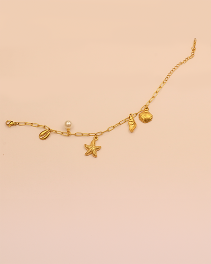 Gold bracelet with starfish, shell, and pearl charms 
